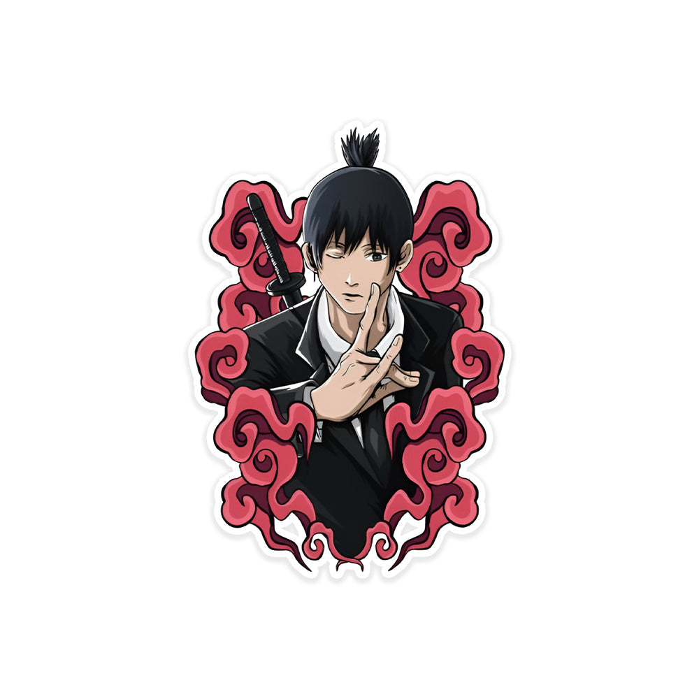 A rectangular sticker with a red background and a white horizontal stripe in the middle. In the center of the white stripe, black Devanagari text reads "घुमक्कड़" which translates to "Wanderer." The red background has faint travel-themed illustrations.