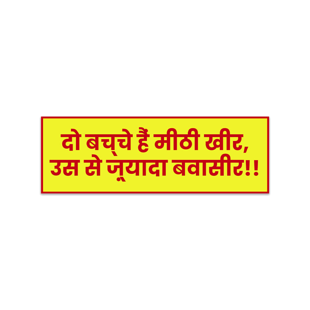 A rectangular sticker with a red background and a white horizontal stripe in the middle. In the center of the white stripe, black Devanagari text reads "घुमक्कड़" which translates to "Wanderer." The red background has faint travel-themed illustrations.