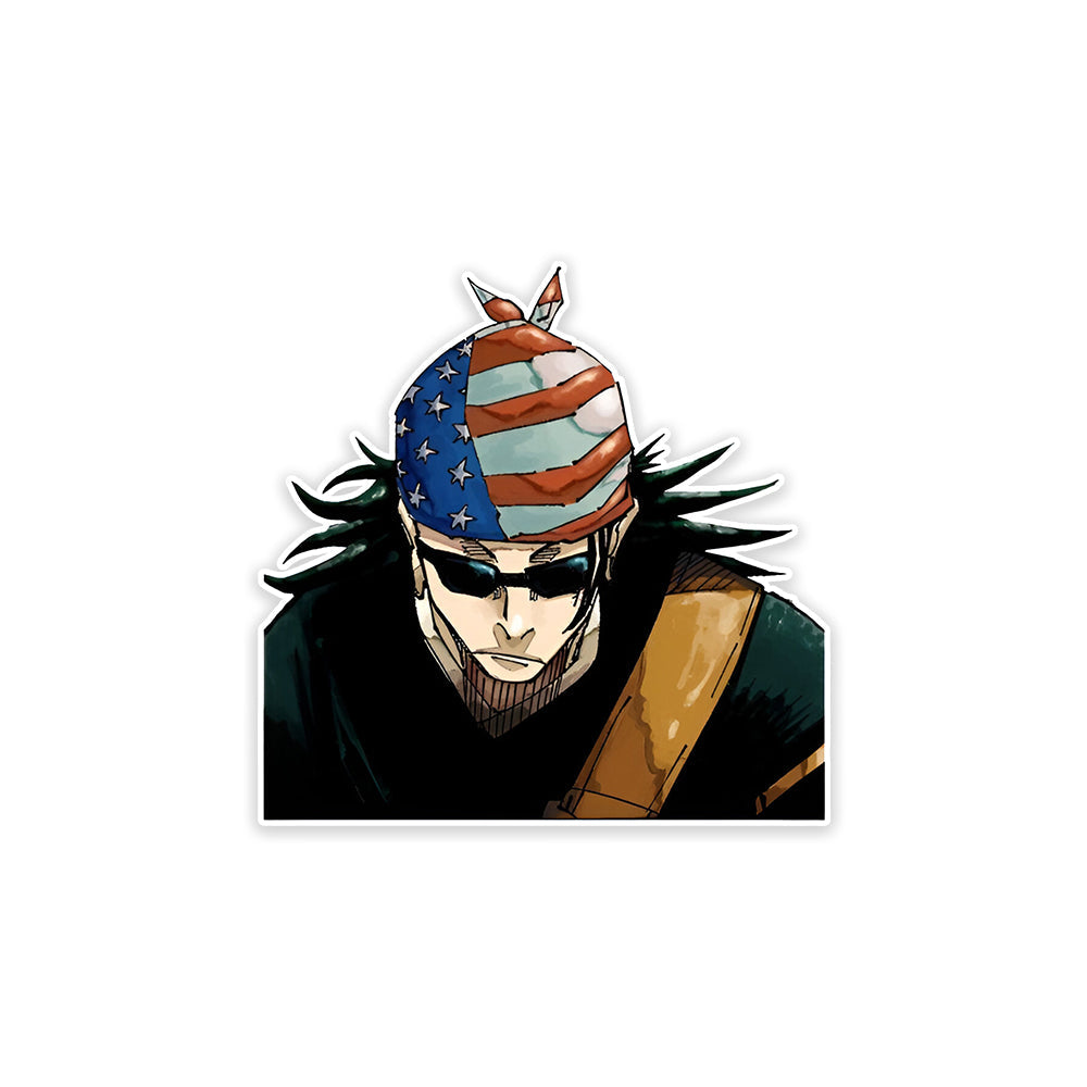 A rectangular sticker with a red background and a white horizontal stripe in the middle. In the center of the white stripe, black Devanagari text reads "घुमक्कड़" which translates to "Wanderer." The red background has faint travel-themed illustrations.