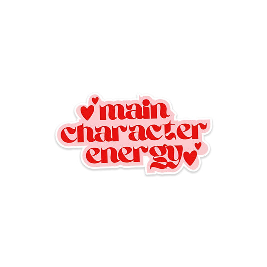 A rectangular sticker with a red background and a white horizontal stripe in the middle. In the center of the white stripe, black Devanagari text reads "घुमक्कड़" which translates to "Wanderer." The red background has faint travel-themed illustrations.