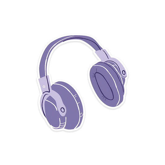 A rectangular sticker with a red background and a white horizontal stripe in the middle. In the center of the white stripe, black Devanagari text reads "घुमक्कड़" which translates to "Wanderer." The red background has faint travel-themed illustrations.