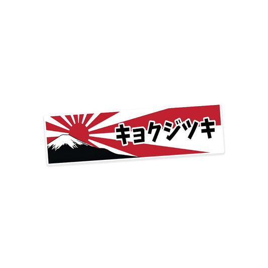 A rectangular sticker with a red background and a white horizontal stripe in the middle. In the center of the white stripe, black Devanagari text reads "घुमक्कड़" which translates to "Wanderer." The red background has faint travel-themed illustrations.