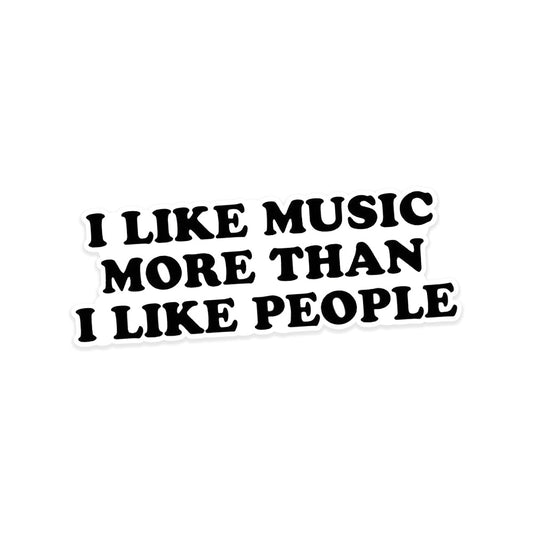 A rectangular sticker with a red background and a white horizontal stripe in the middle. In the center of the white stripe, black Devanagari text reads "घुमक्कड़" which translates to "Wanderer." The red background has faint travel-themed illustrations.