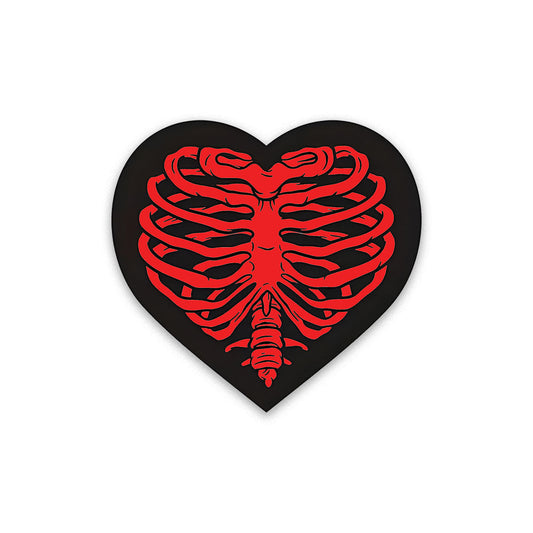 A rectangular sticker with a red background and a white horizontal stripe in the middle. In the center of the white stripe, black Devanagari text reads "घुमक्कड़" which translates to "Wanderer." The red background has faint travel-themed illustrations.